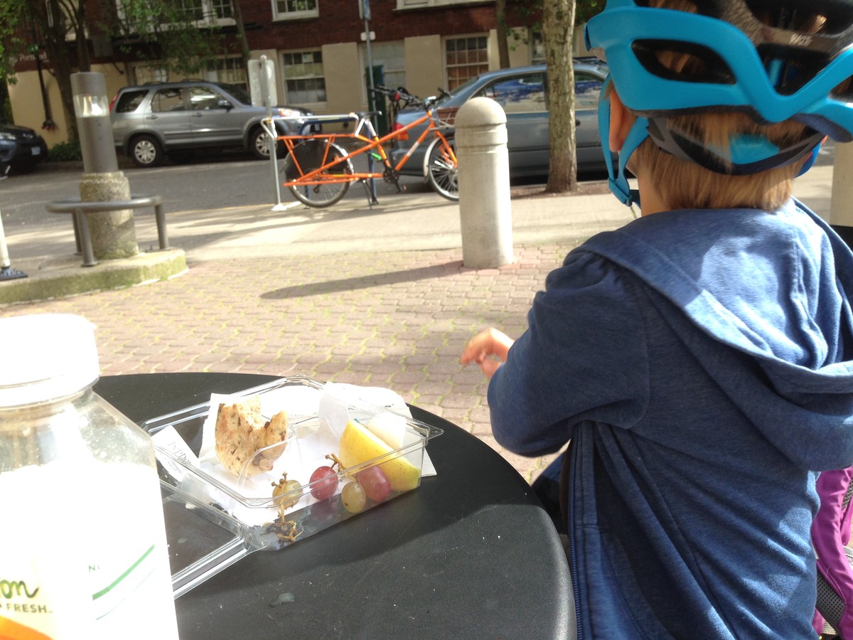 Iris eating a snack and looking at the cargo bike